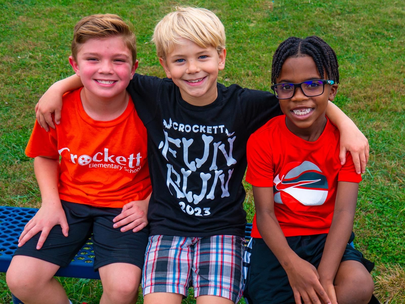 3 boys sitting and smiling